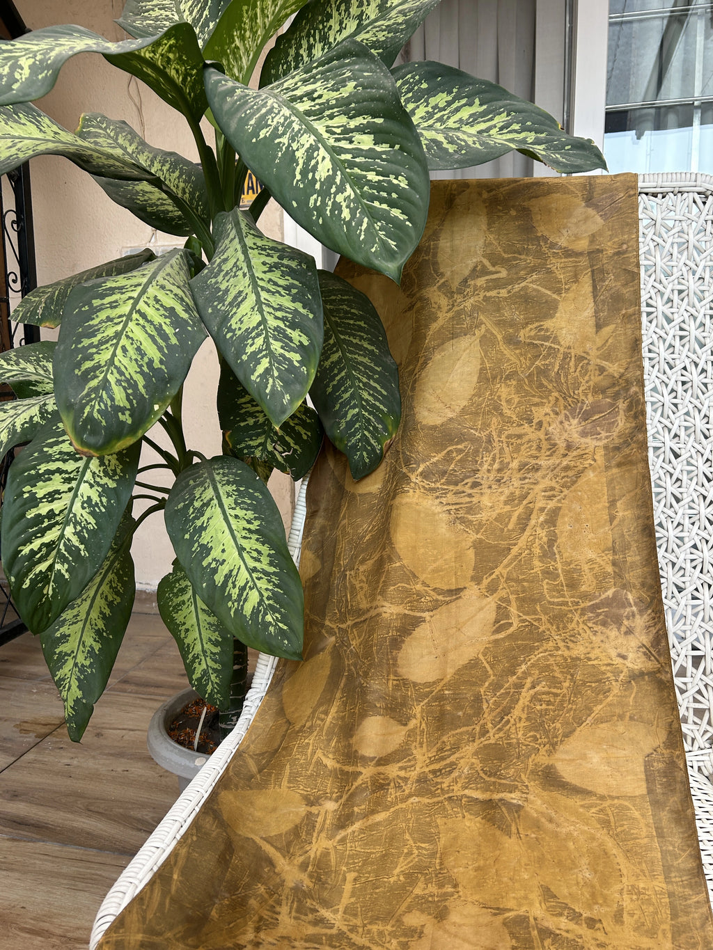 Handcrafted pure silk scarf naturally dyed with marigold flowers and eco printed with real jamun leaves, featuring golden yellow botanical patterns created using sustainable eco-printing techniques.
