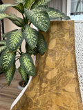 Handcrafted pure silk scarf naturally dyed with marigold flowers and eco printed with real jamun leaves, featuring golden yellow botanical patterns created using sustainable eco-printing techniques.