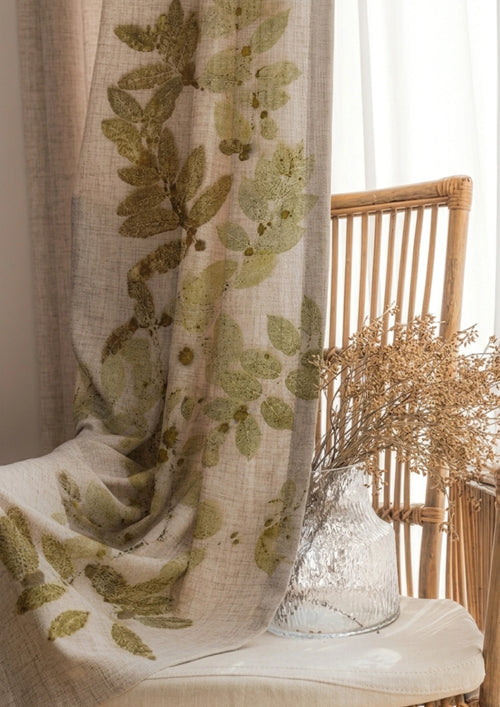 Decorative Botanical Breeze eco-printed linen curtain featuring natural leaf impressions on premium linen fabric, handcrafted sustainable window décor inspired by nature curtain with leaf pattern on a chair with a vase of dried flowers.