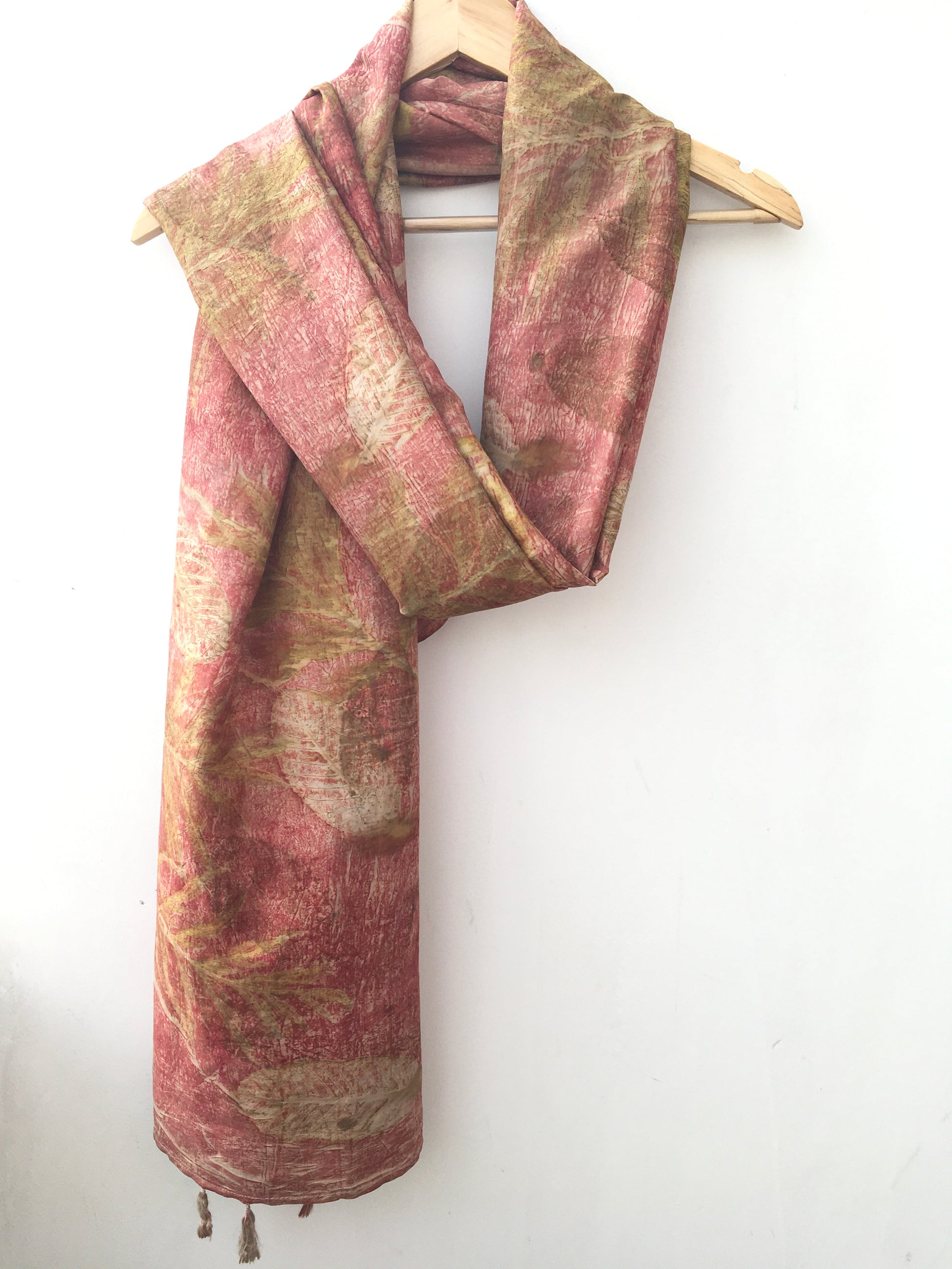 Folded ecoprinted silk scarf dyed with madder and patterns of leaves 