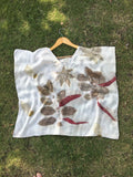 Leaves patterned Kaftan Flared Top on a hanger against a grassy background