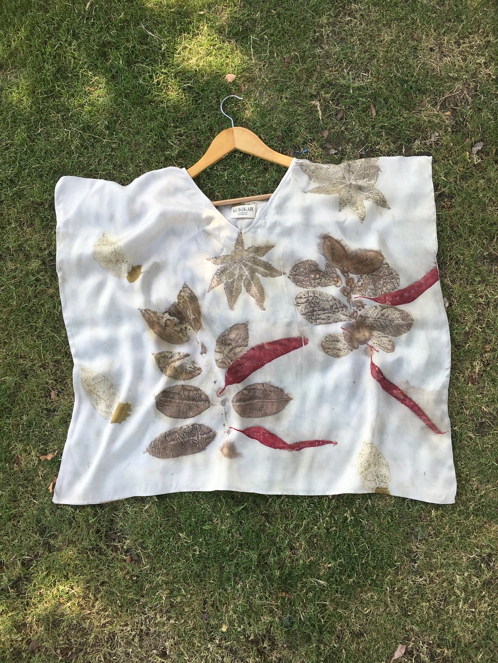 White Kaftan Flared Top with leaf patterns on a grassy background