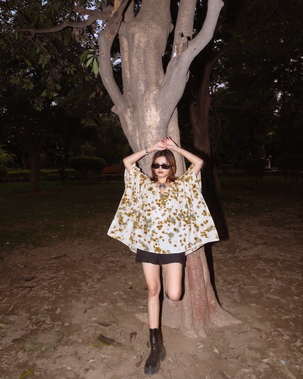 girl posing in Kaftan Flared Top with a tree in a dark outdoor setting 