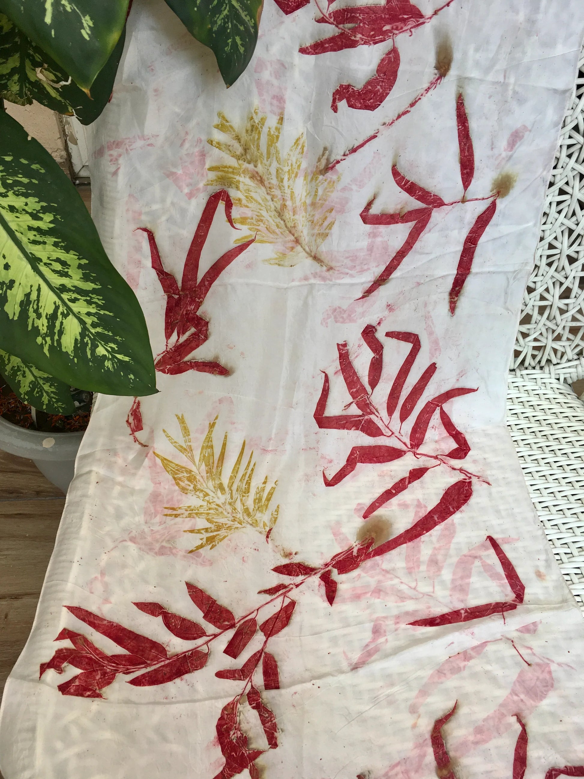 Handmade botanical silk scarf featuring red eucalyptus leaves, natural dyes, and sustainable eco-printing craftsmanship.