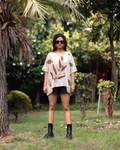 girl wearing a ecoprinted Kaftan Flared Top and black shorts standing in a garden.