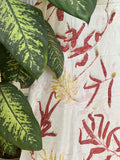 Close-up of green leaves with a textured red and white Ecoprinted pure silk scarf