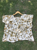 Kaftan Flared Top with brown marigold spots on a grassy background