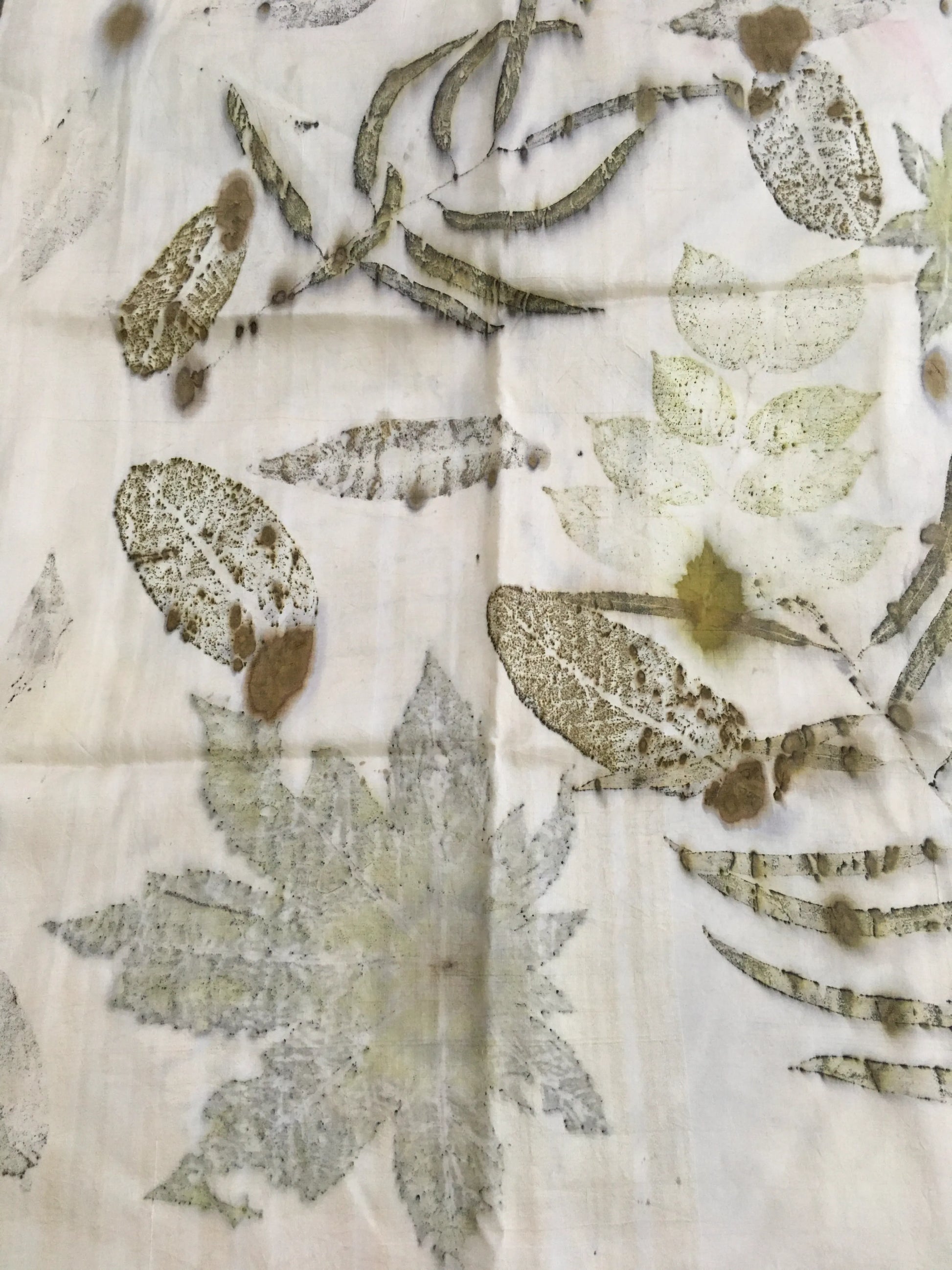 Close-up of a Handmade botanical silk scarf featuring real leaf prints on white silk with soft green natural tones.